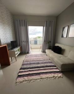 a living room with a couch and a rug at Apartamento aconchegante e bem localizado! in Vitória
