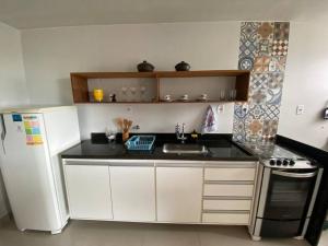 een kleine keuken met een wastafel en een koelkast bij Apartamento aconchegante e bem localizado! in Vitória