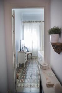 einen Flur mit einem Zimmer mit einem Fenster und einem Tisch in der Unterkunft Palacete de La Alameda - Adults Only- in Cádiz