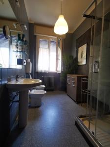 a bathroom with two sinks and a toilet and a shower at Affittacamere Room ospedale Maggiore in Parma