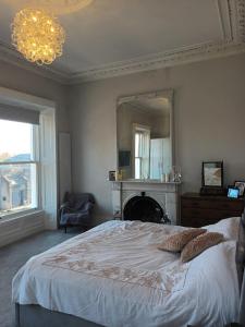 a bedroom with a bed and a mirror and a chandelier at Eglinton Road - Sleeps 6 on room only basis in Bray