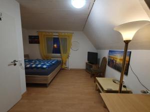 um quarto com uma cama, uma secretária e um candeeiro em Geräumiges Ferienhaus in Bad Salzuflen mit einfacher Ausstattung, für Geschäftsreisende, Gruppen oder Familien geeignet, 4 Schlafzimmer em Bad Salzuflen