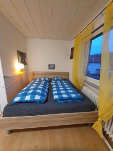 a bed with blue and white pillows in a room at Geräumiges Ferienhaus in Bad Salzuflen mit einfacher Ausstattung, für Geschäftsreisende, Gruppen oder Familien geeignet, 4 Schlafzimmer in Bad Salzuflen