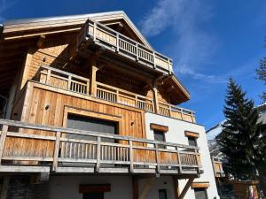 a house with a balcony on the side of it at Chalet Red Mount - Esprit chalet au pied des pistes in Les Deux Alpes