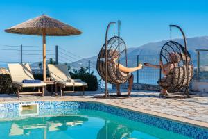 a woman jumping into a swimming pool at Kefalonia Horizon Villas in Agia Effimia