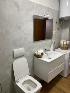 Baño blanco con aseo y lavamanos en Aimari’s Apartment, en Shkodër