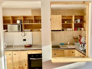 cocina con armarios de madera y microondas en Urban Lodge Providencia, en Santiago