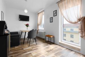 sala de estar con mesa, sillas y ventana en Apartment LYLY, en Karlovy Vary