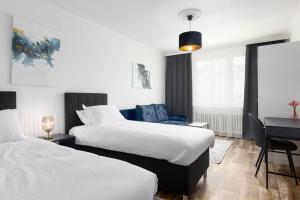 Habitación de hotel con 2 camas y escritorio en Apartment LYLY, en Karlovy Vary