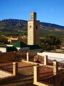 budynek z wieżą zegarową na górze w obiekcie Riad Inaya Fez w Fezie