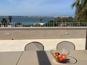 un bol de fruta sentado sobre una mesa en 5E Villa Charme-Sea and Ortigia view-Whirlpool roof Terrace en Siracusa