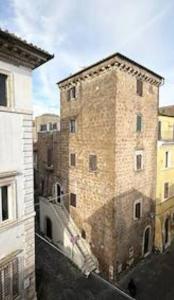 un gran edificio de ladrillo con una sombra. en CHARME, en Civita Castellana