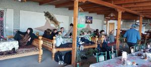 a group of people sitting on benches in a room at Hotel Rahmon - 2 in Samarkand