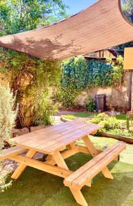 a wooden picnic table in a garden with a canopy at Urban Lodge Providencia in Santiago