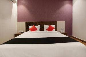 1 dormitorio con 1 cama blanca grande con almohadas rojas en S B Excellency, en Jodhpur