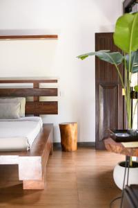 a bedroom with a bed and a wooden table at Roots Retreat in Unawatuna