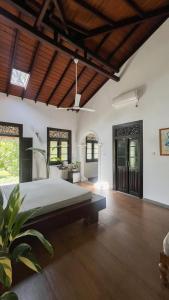 a large bedroom with a large bed and wooden floors at Roots Retreat in Unawatuna