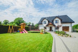 ein Haus mit einem Hof mit Spielplatz in der Unterkunft Pokoje Gościnne Amir in Karwieńskie Błoto Pierwsze