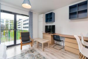 - un salon avec un bureau, une table et des chaises dans l'établissement Bronowice Standard Studio, à Cracovie