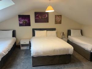 a bedroom with two beds and paintings on the wall at Skegness Holiday Cottages in Skegness