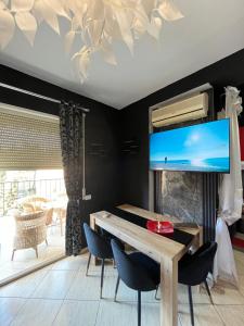 a dining room with a table and a flat screen tv at Bega's Apartment in Golem, Durrës in Golem