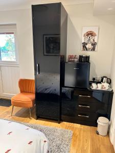 a bedroom with a large black cabinet with a television at Foxes Den at Foxesway in Kirkby on Bain