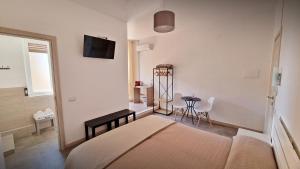 敘拉古的住宿－MERIDIAN B&B，一间卧室配有一张床、一张桌子和一台电视