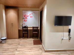 Habitación con mesa y TV en la pared. en Hotel Mellow Mood, en Bhubaneshwar