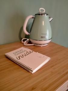 a tea kettle and a notebook on a wooden table at The green place alloggio turistico in Rome