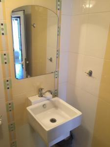a bathroom with a white sink and a mirror at Guest House Gloria in Nesebar