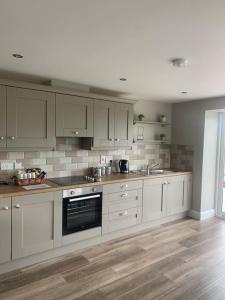 eine Küche mit weißen Schränken und einer Arbeitsplatte in der Unterkunft Betty's Cottage in Newcastle