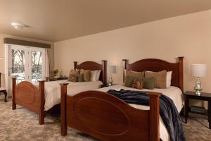 een slaapkamer met 2 bedden en een raam bij The Oakwood Inn in Okoboji