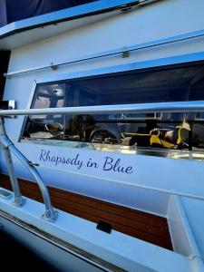 ein Fenster eines Bootes mit den Worten Glück in Blau in der Unterkunft Rhapsody in Blue in Chertsey