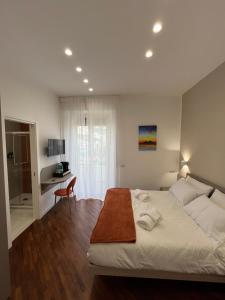 ein Schlafzimmer mit einem großen weißen Bett und einem Schreibtisch in der Unterkunft Maison Grimaldi in Neapel