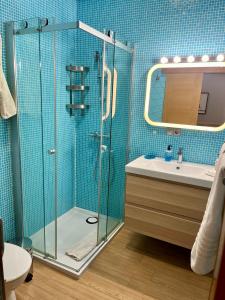 a bathroom with a glass shower and a sink at Apartamento Las Canteras in Las Palmas de Gran Canaria