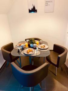 een tafel met borden eten en sinaasappelsap bij Modernes, zentrales Apartment in Troisdorf, Region Köln Bonn, maximal für 4 Personen, Parkplatz & Netflix inklusive in Troisdorf