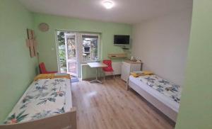 1 dormitorio con 2 camas, escritorio y ventana en noclegi Julia en Kielce