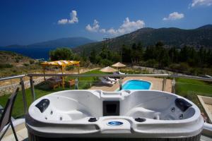 un jacuzzi en el balcón de una casa en Kefalonia Horizon Villas en Agia Efimia