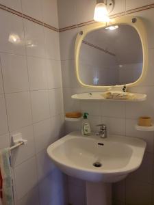 bagno con lavandino bianco e specchio di Sabaudia Villa Annamaria a Sabaudia