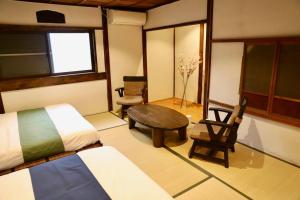 a bedroom with a bed and a table and a chair at 動物園前駅まで徒歩5分/通天閣近く/道頓堀エリアまで電車3分/大阪グルメ旅行に最適！ in Osaka