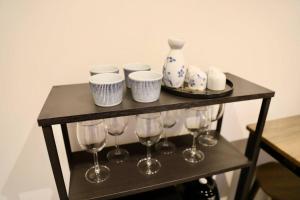 a shelf with wine glasses and vases on it at 動物園前駅まで徒歩5分/通天閣近く/道頓堀エリアまで電車3分/大阪グルメ旅行に最適！ in Osaka