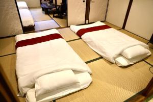 two beds sitting on the floor in a room at 動物園前駅まで徒歩5分/通天閣近く/道頓堀エリアまで電車3分/大阪グルメ旅行に最適！ in Osaka