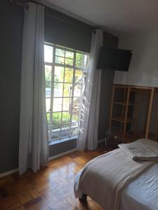 1 dormitorio con cama y ventana grande en Die Eend Studio, en Centurion