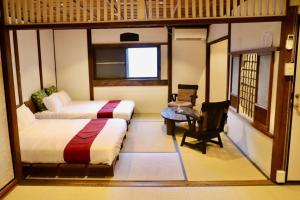 a room with two beds and a desk and a chair at 動物園前駅まで徒歩5分/通天閣近く/道頓堀エリアまで電車3分/大阪グルメ旅行に最適！ in Osaka