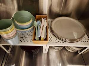 a shelf with plates and bowls and utensils on it at 動物園前駅まで徒歩5分/通天閣近く/道頓堀エリアまで電車3分/大阪グルメ旅行に最適！ in Osaka