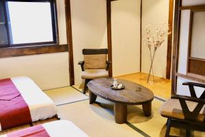 a room with a bed and a table and a chair at 動物園前駅まで徒歩5分/通天閣近く/道頓堀エリアまで電車3分/大阪グルメ旅行に最適！ in Osaka
