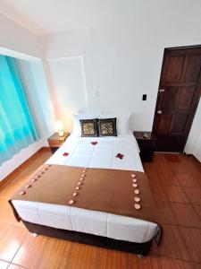 ein Schlafzimmer mit einem großen weißen Bett in einem Zimmer in der Unterkunft Ortega's House Machupicchu in Machu Picchu