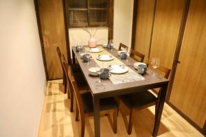 a dining room table with chairs and a vase on it at 動物園前駅まで徒歩5分/通天閣近く/道頓堀エリアまで電車3分/大阪グルメ旅行に最適！ in Osaka