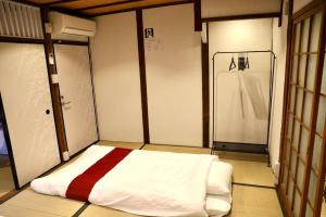 a room with a bed in a room with a shower at 動物園前駅まで徒歩5分/通天閣近く/道頓堀エリアまで電車3分/大阪グルメ旅行に最適！ in Osaka