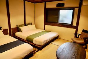 a room with two beds and a window and a chair at 動物園前駅まで徒歩5分/通天閣近く/道頓堀エリアまで電車3分/大阪グルメ旅行に最適！ in Osaka